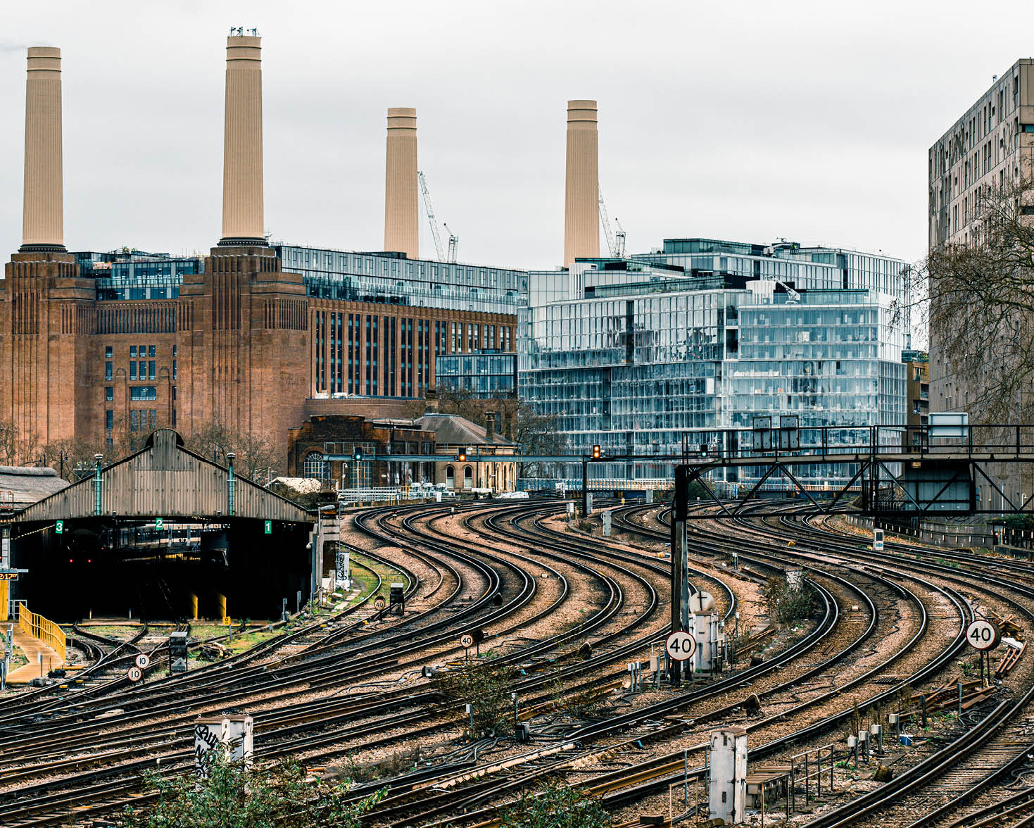 Battersea Power Station the iconic decommissioned coal-fired power station located on the south bank of the River Thames in London. The Art Deco landmark surrounded by cranes during redevelopment building work - seen from Victoria Railway Station approach and shunting yard with approaching trains